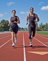 Two athletes run around a red running track